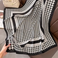 Gros plan d'un foulard en soie à motif pied-de-poule sur fond en cuir de qualité supérieure - 90*90cm / Noir