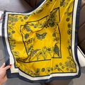 Vista detallada de un pañuelo de seda amarillo con estampado floral y mariposa - 90*90cm / Amarillo / 【atributos Del Producto】una Bufanda Cuadrada De Color Amarillo Brillante Que Visualmente Se Estima Que Está Hecha De Seda Real O Seda Sintética De Alta Calidad. La Bufanda Está Estampada Con Exquisitos Patrones Florales Y Vegetales Negros Con Un Patrón De Mariposa En El Centro Y Un Diseño De Borde Contrastante En Blanco Y Negro. 【presentación Visual】la Imagen Fue Tomada En Un Entorno Doméstico Con La Bufanda Extendida Naturalmente Sobre Un Sofá De Cuero Marrón. Un Bolso De Cadena Blanco Y Una Revista Están Dispersos En El Fondo Creando Un Tono General Cálido Armonioso Y Sofisticado. La Calidad De La Imagen Es Alta Con Una Fuerte Resolución Y Una Excelente Textura. El Atractivo Estético Es Alto Con Una Puntuación General De 8.2. Los Accesorios Y El Estilo Del Producto Están Muy Bien Combinados Creando Una Atmósfera Elegante E Informal. 【contenido Del Texto】solo Se Ve Una Pequeña Cantidad De Texto Borroso En Inglés En La Página Izquierda De La Revista Sin Marcas De Agua Ni Eslóganes De Marketing En Chino. 【etiquetas Logísticas】ninguna. 【riesgo De Infracción】el Cuerpo Principal Del Producto Tiene Un Estilo De Impresión Original Y No Se Detectó Ninguna Infracción De Marca. No Hay Logotipos De Marcas Filtrados En El Fondo Ni En Los Accesorios. 【parámetros Del Producto】tamaño Cuadrado Grande Impresión Multicolor Accesorio Para El Hogar/viaje.