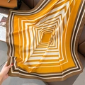 Dettaglio di una sciarpa morbida a righe su un divano in pelle con look da rivista - Giallo / 90cmx90cm