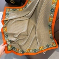 Detail view of vintage orange silk scarf with gold chain print draped on leather chair - 90x90cm / Orange Edge (HSM-16)