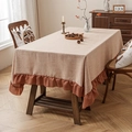 Beige linen tablecloth with orange ruffled edges and natural rustic texture - Caramel color