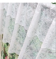 Détail du rideau en dentelle blanche montrant la broderie florale et l'ourlet à volants - 145cmx45cm / Blanc