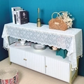 Eleganter weißer Blumen-Spitzen-Tischläufer mit Quasten auf weißem Schrank vor blauer Wand - 60*60cm / Weiß