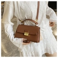 Detailed view of brown lychee-grain leather handbag with golden metal twist lock and strap - Brown