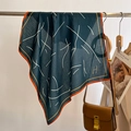 Detail of silk square scarf featuring abstract lines and H logo hanging over a leather bag - 68*68cm / Peacock Blue