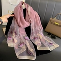 Detail of floral embroidery and sequins on silk blend scarf draped over a black mannequin - Dusty Pink