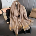 Dettaglio di una sciarpa in seta color champagne con sottili strisce in filo dorato - Cammello