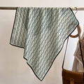 Close-up of light green silk scarf with black geometric pattern hanging on a metal bar - 68*68cm / Aqua Green