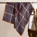 Detail of houndstooth silk scarf with chain pattern draped on a metal rack - Purple Coffee