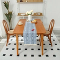 Dark blue table runner with geometric white patterns and decorative tassels on wood table - Blue Stripe