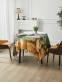 Round tablecloth featuring impressionist country landscape with cottage and wheat fields - Orange