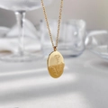 Elegante goldene Halskette mit ovalem Anhänger und filigraner Blumengravur für Damen - Nelken-Stil