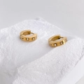 Detalle macro de pendientes de aro dorados con estrellas y circonitas blancas - Estilo de Hexagrama con Circonita