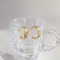 Gold triple-layered C-shaped hoop earrings with twisted texture on glass display - Matte C Shape Style