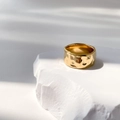 Detailed view of gold-plated titanium ring with irregular hammered crater texture - US 6 / Hammered Model