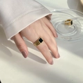 Dettaglio dell'anello a sigillo dorato rettangolare con onice nero e fascia zigrinata - US 6 / Stile Quadrato