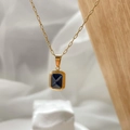 Dettaglio del ciondolo con gemma blu taglio smeraldo e catena a maglie dorate - Zirconia blu quadrata
