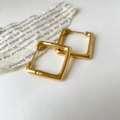 Dettaglio di orecchini a cerchio quadrati placcati oro con finitura lucida a specchio - Quadrato