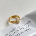 Detailed close-up of a triple-band gold ring with a sparkling oval cubic zirconia stone - US 6 / White Zircon