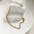 Dettaglio del bracciale a catena piatta dorata con targhetta K18 e chiusura a moschettone - Catena a Serpente Sottile