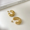 Details von klobigen goldenen C-förmigen Creolen mit hochglanzpoliertem Metall-Finish - Polierter Hohler C-Stil