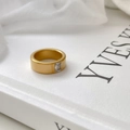 Macro shot of matte gold titanium ring featuring a rectangular zircon on a white background - US 6 / Matte Gold