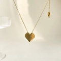 Collana dorata con ciondolo a cuore pixelato su un elegante sfondo chiaro - Quadri Cuore