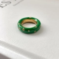 Détail d'une bague en émail vert avec cristaux incrustés sur fond papier blanc - Style Émail Vert et Zirconia