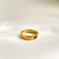 Makroaufnahme eines goldenen minimalistischen Rings mit ovalem smaragdgrünem Stein - US 6 / Breites Band Ovaler Grüner Stein Stil
