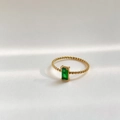 Macro di anello a fascia intrecciata in oro con zircone verde rettangolare taglio smeraldo - US 6 / Smeraldo