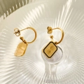 Detail of gold rectangular earrings with black enamel border and radiant sunburst motif - Rectangular Sunburst Style With Black Enamel