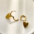Detailed view of polished golden heart-shaped charms on minimalist hoop earrings - Heart Style