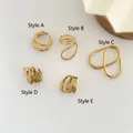 Draufsicht auf fünf minimalistische goldene hohle Herz- und geometrische Ringe auf weiß - US 6 / A-Stil Doppelschicht Offen