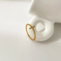Macro shot of gold beaded cross ring hanging on white ceramic, showing refined craftsmanship - US 7 / Beaded Cross Style