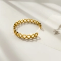 Detailweergave van een gouden open armband met geometrisch honingraatmotief - Gouden Honingraat Stijl