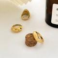 Makro-Detail von drei goldpolierten Dome-Ringen auf einer minimalistischen weißen Fläche - US 6 / Konkav D-Stil