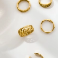 Detailansicht goldener geometrischer Ringe mit Webmustern und Spitzenstrukturen - US 6 / Kettenweben Breiter Stil
