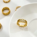 Nahaufnahme eines goldenen Rings mit Sternenmuster auf weißem Porzellan - US 6 / Stern Hohl Stil