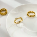 Nahaufnahme von 18K vergoldeten geometrischen Hohlringen auf einem weißen Keramikteller - US 6 / Raute Hohl Stil