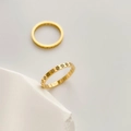 Detailed view of two gold thin rings featuring hollow floral daisy patterns on stones - US 6 / Flower Hollow