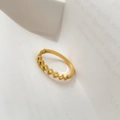 Close-up of golden geometric hollow diamond ring placed on white book pages for detail - US 6 / Hollow Square