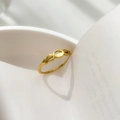 Detailed view of gold geometric ring casting a romantic heart-shaped shadow - US 6 / Hollow Oval