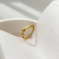 Detailed close-up of golden olive leaf ring on white plate edge with natural shadows - US 6 / Leaf