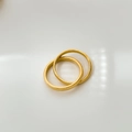 Detailopname van twee gouden ringen met gepolijste afwerking en diagonale textuurpatronen - US 6 / Dubbele band met draaipatroon