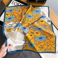 Elegante foulard in seta floreale con base gialla e bordo blu su tavolo in legno - Giallo Zenzero Floreale (ZS-381-Giallo)