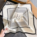 Elegant striped silk square scarf with minimalist text, draped on a luxury white handbag - Beige Striped Letter (ZS-393)