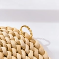 Detailansicht eines goldenen Ringes mit Sternenmuster auf einer geflochtenen Strohmatte - US 6 / Pentagramme