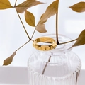 Detail van een gouden brede ring met geometrische piramidestructuur op glas - US 8 / Rasterpatroon