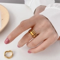 Detail van gelaagde gouden holle brede ringen op hand met minimalistisch golfpatroon - US 8 / 4-Laags Hol Open