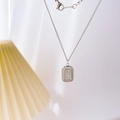 Détail du pendentif damier argenté serti de zircons sur une fine chaîne maille jante - Chocolat 3D Plein Zircone / Argenté